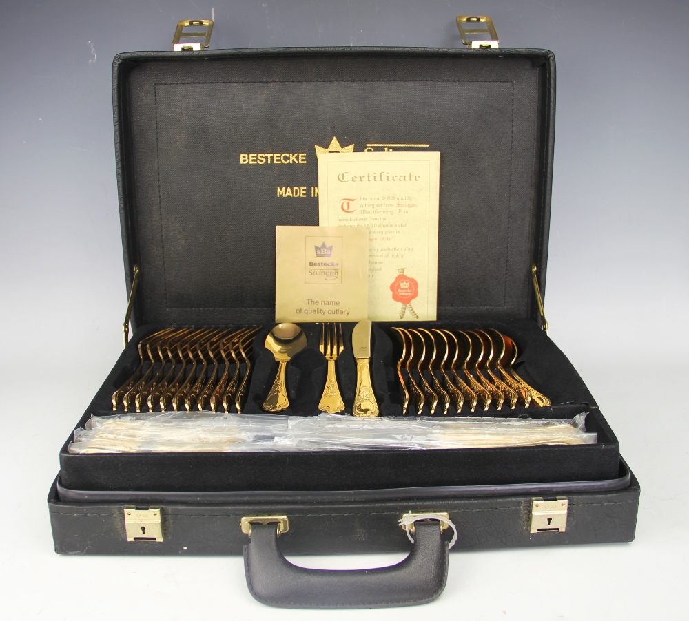 A Bestecke Solingen gold plated canteen; comprising twelve dinner forks, twelve dinner knives,