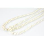 A single strand graduated cultured pearl necklace with attached white metal navette shaped clasp