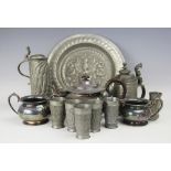 An embossed pewter flagon, possibly German, 23cm, a similar armorial dish, 32cm diameter,