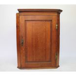 A George III oak hanging corner cabinet,