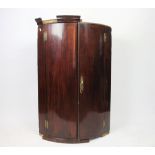 A George III mahogany bow front hanging corner cabinet,