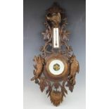 A 19th century Black forest barometer, carved with scrolling vines, a wild boar,