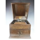 A vintage HMV oak cased record player, with hinged top enclosing record deck, with winder,