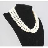 A three strand freshwater pearl necklace, with attached silver bead clasp,