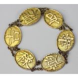 A Chinese gold bracelet, the six panels depicting Chinese characters,