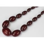 A 'cherry' amber bead necklace, designed as twenty seven beads, graduating from 14mm - 35mm wide,