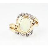 An opal and diamond set dress ring, the central oval opal within a cross-over diamond set surround,