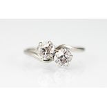 A two stone diamond cross-over ring, the two old-brilliant cut diamonds (each of approx 0.