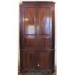 A 19th century mahogany corner cabinet, with moulded cornice above four panelled doors,