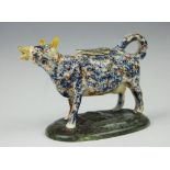 A pearl ware cow creamer and cover, early 19th century, modelled standing,