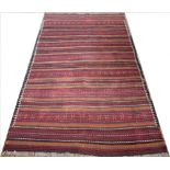 A 20th century wool tribal rug, with striped detailing,