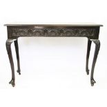 A Victorian carved oak side table, on cabriole legs with fitted castors,