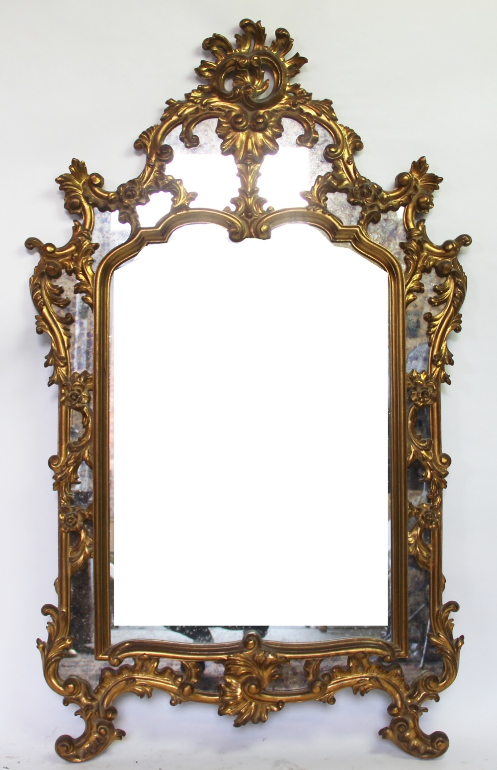 A George I style gilt composition wall mirror, with elaborate shell and scroll frame,