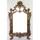 A George I style gilt composition wall mirror, with elaborate shell and scroll frame,