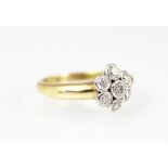 A seven stone diamond daisy cluster ring, the round brilliant cut diamonds,