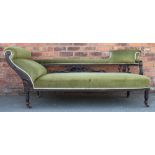 A late Victorian carved and stained wood chaise longue, with green upholstery, on turned legs,