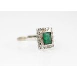 A diamond and emerald Art Deco style ring, the central emerald within a diamond set surround,