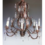 A modern Louis XV style bronzed metal eight light chandelier decorated throughout with scrolling