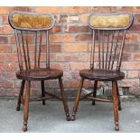 A pair of Edwardian stained beech chairs, with circular seats, with an oak dining table,