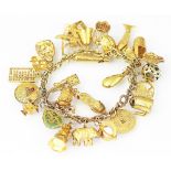 A yellow metal decorative link bracelet hung with numerous yellow metal charms, many stamped '14k',