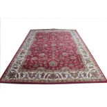 A Chinese wool carpet, worked with an all over floral design against a red ground,