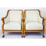 A pair of satin birch Biedermeier style salon tub chairs, with foliate ivory upholstery,