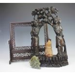 A Chinese stained hardwood figural stand, modelled as two figures supporting a floral surmount,