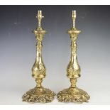 A pair of lacquered brass table lamps, cast with flowers and scrolls,
