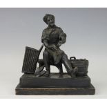 A cast spelter figural spill vase and striker, modelled as a seated cobbler,