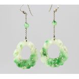 A pair of carved jade drop earrings, each designed as a circular carved drop,