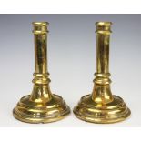 A pair of George III brass candlesticks, each with a later engraved crowned V.