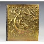A Newlyn School type embossed brass Arts and Crafts folio, depicting a nymph riding a dolphin,