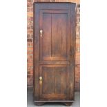 A George III rustic oak corner cupboard, with two panelled doors, on later bracket feet,
