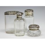 A selection of four cut glass jars and silver covers, to include a London 1905 example,