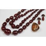 A 'cherry' amber bead necklace, the fifty five with screw clasp and on knotted string,