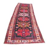 An Iranian full pike wool runner, worked with six medallions against a blue ground,