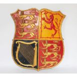 A moulded and painted plaster Royal Arms armorial shield, with quartered lion, harp and three lions,