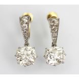 A pair of diamond drop earrings, each designed as a cushion shaped,