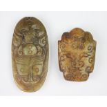 A Chinese jade coloured hardstone pendant, with carved bat and mask detailing, 8cm long,