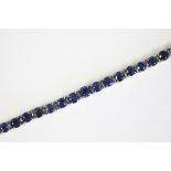 A sapphire set line bracelet, designed as forty three uniform, circular cut, untested sapphires,