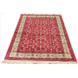 A Kashmir rug, with an all over floral design against a red ground, with golden border,