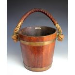 A brass bound coopered peat bucket made from a battle ship, with rope handle,