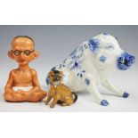 A Sitzendorff porcelain model of a seated wild boar, with blue and white floral detailing,