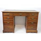 An Edwardian walnut pedestal desk, with an arrangement of nine drawers, on plinth base,