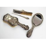A selection of Art Nouveau silver dressing table wares comprising; a silver backed hand mirror,