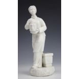 A Chinese blanc de chine figure, modelled as a female attendant carrying a domestic container,