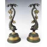 A pair of 20th century brass candlesticks, each modelled with cast dolphin stem, upon socle base,