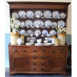 A George III oak dresser, with moulded cornice above three shelves, over three short drawers,