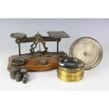 A set of early 20th century brass postal rate scales, mounted upon moulded wooden platform,