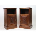 A pair of late Victorian carved walnut bedside cupboards,
